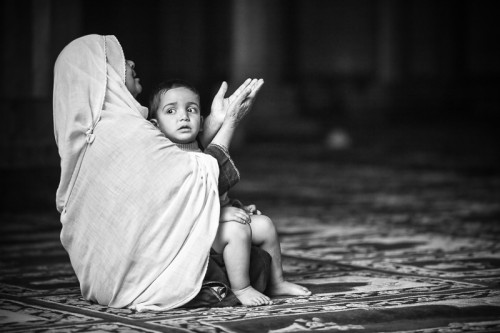 Kashmir. A woman worships at the mosque with her child.